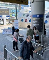 광주 송정역 입구에서 2025 남도국제미식산업박람회 홍보물을 시민들에게 나눠주고 있는 관계자들 모습