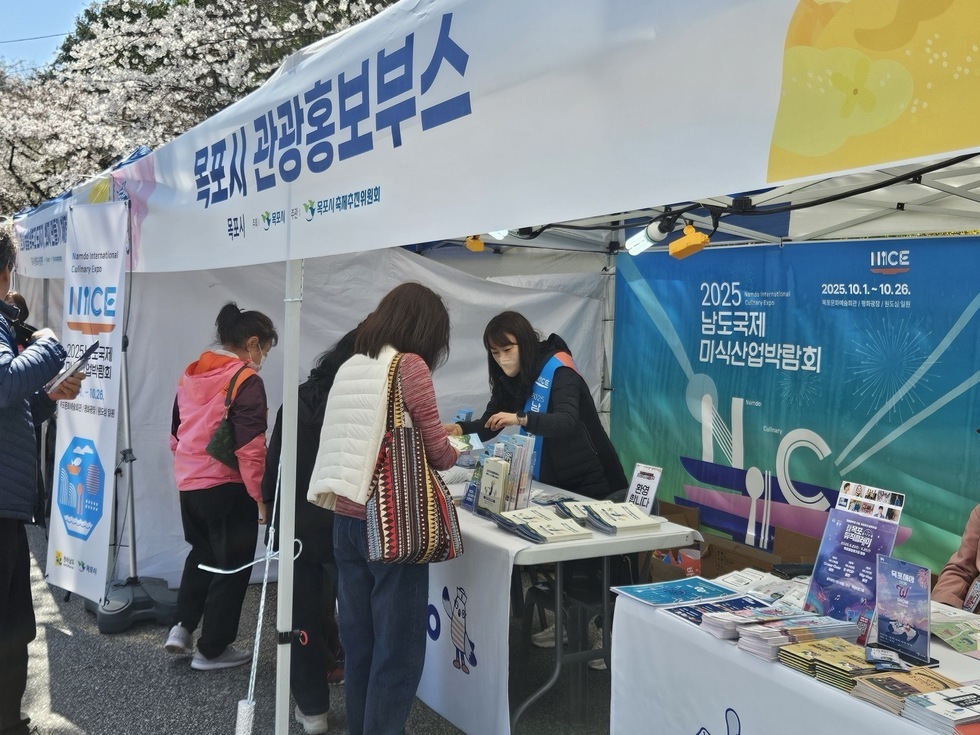 목포시 관광 홍보부스에서 시민에게 2025 남도국제미식박람회 홍보중인 직원 모습