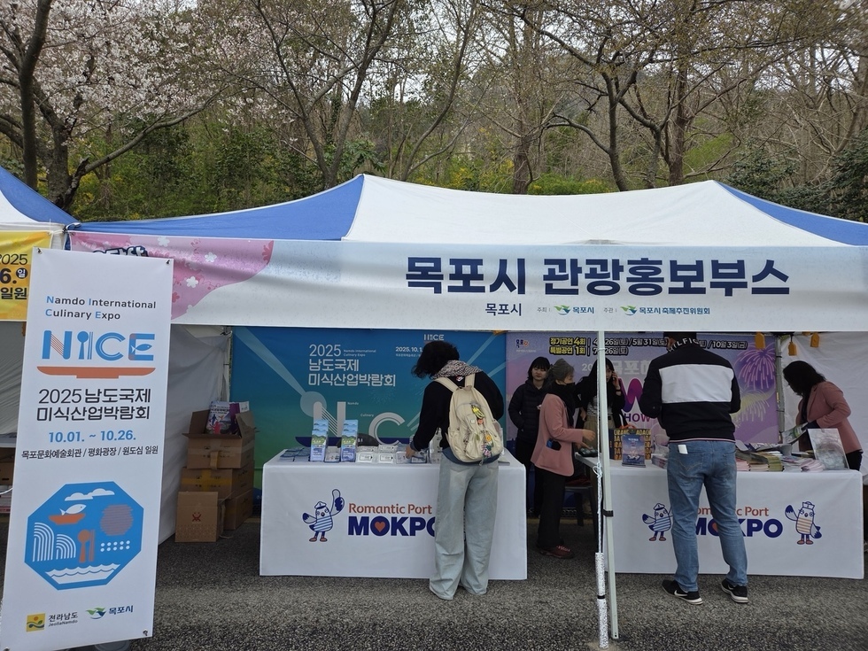 목포시 관광 홍보부스에서 홍보물을 살펴보고 있는 시민 모습