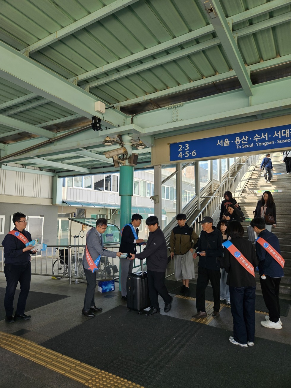 목포역사 안에서 2025 남도국제미식산업박람회 홍보물을 시민들에게 나눠주고 있는 관계자들 모습