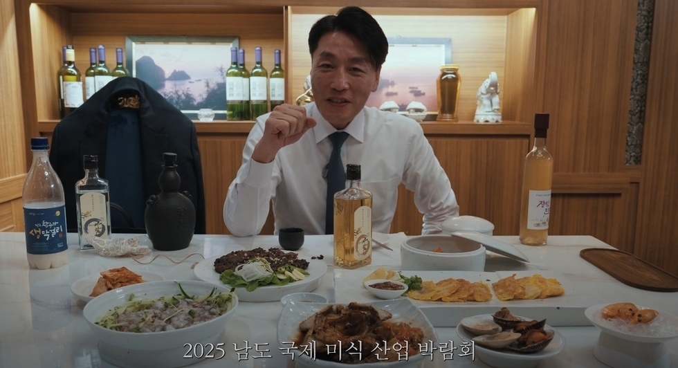남도 음식 한 상이 차려진 식탁 앞에서 환하게 웃으며 전통주를 즐기는 마츠다