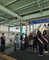 광주 송정역 입구에서 2025 남도국제미식산업박람회 홍보물을 시민들에게 나눠주고 있는 관계자들 모습